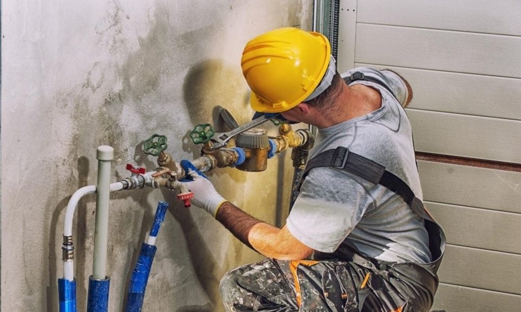 Pink Flamingo Plumbing technician servicing exterior shut-off valves